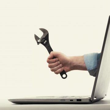 restoro system optimizers hand holding wrench coming out of laptop monitor